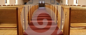 Aisle of traditional Christian church with empty pews