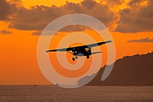 Ait travelling in Costa Rica. Evening sunset in sea coast of Corcovado NP, Costa Rica. Aircraft on the orange sky with dark clouds