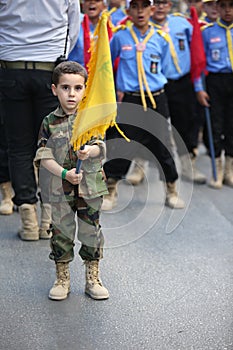 Hezbollah`s child supporter Carries the flag of Hezbollah