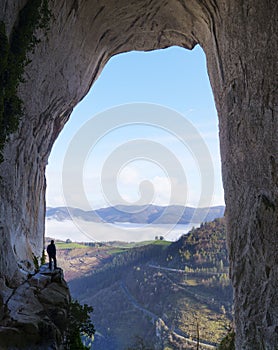 Aitzulo Cave. Hiker in the eyes of Aitzulo located in the Natural Park of Aratz-Aizkorri, Euskadi