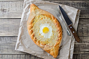 Ajarian khachapuri with egg on wooden background