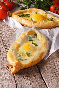 Ajarian khachapuri and fresh vegetables close-up. Vertical