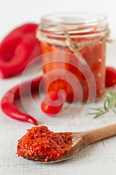 Ajvar in a jar with red chilli peppers