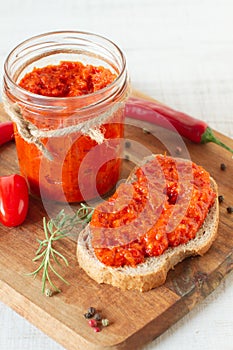 Ajvar in a jar with red chilli peppers
