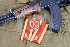 AK 47 with Soviet Army Cadet shoulder mark and Commandant shoulder patch on khaki uniform background photo