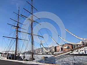 Aker Brygge in Oslo with a sailing ship lying in the Oslofjord  with ice floes, Norway