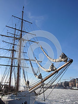 Aker Brygge in Oslo with a sailing ship lying in the Oslofjord  with ice floes, Norway