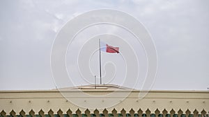 The Al-Adaam National Flag of Qatar flying above a building in Doha, Qatar