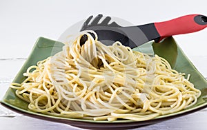 Al dente spaghetti pasta on a plate with pasta fork on white background photo