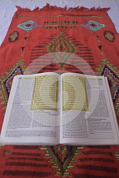 Al Quran di sajadah dengan latar belakang putih. photo