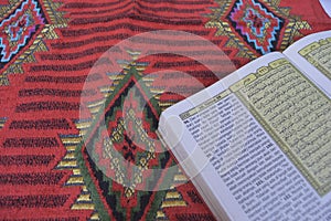 Al Quran di sajadah dengan latar belakang putih. photo