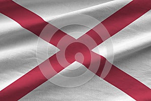 Alabama US state flag with big folds waving close up under the studio light indoors. The official symbols and colors in