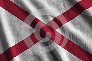 Alabama US state flag with big folds waving close up under the studio light indoors. The official symbols and colors in