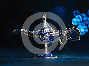 Aladdin`s magical lamp, jeweled on a blue background. Arabian fairy tales, wish fulfillment symbol, antiques. There are no people