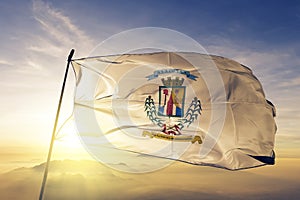 Alajuela Province of Costa Rica flag textile cloth fabric waving on the top sunrise mist fog