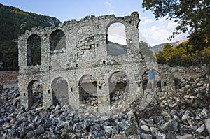 Alakilise ruins along Lycian way hiking trail, Male tourist stands on wall remains of Alakilise or Church of the Angel Gabriel