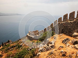 Alanya Castle fortress wall and Mediterranean Sea in Alanya harbor. Alanya, Antalya, Turkey