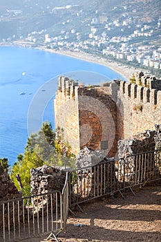 Alanya fortress walls on a rocky peninsula. View of the city beach Cleopatra. Turkey