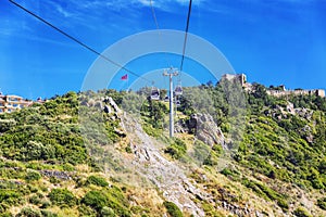 Alanya, Turkey, 05/08/2019: Cable car in the city. Booths with people riding on cables against a blue sky