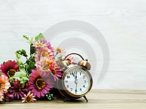 Alarm clock and artificial flowers bouquet with space background