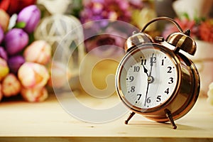 Alarm clock and artificial flowers bouquet with space background