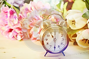 Alarm clock and artificial flowers bouquet with space background
