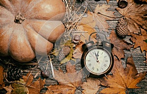 Alarm clock on autumn table.