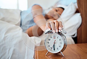 Alarm clock, bedroom and woman stop time to wake up from early morning sleeping at home, house and apartment. Tired