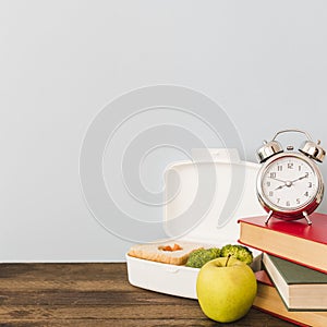 alarm clock books near healthy food. High quality photo