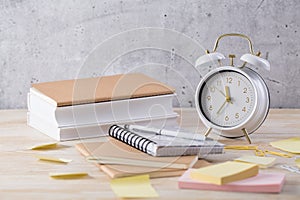 Alarm clock and books - time management and procrastination concept