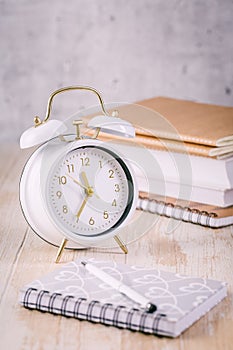 Alarm clock and books - time management and procrastination concept