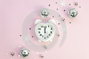 Heart shaped Alarm clock and Christmas mirror balls on pink background. Flat lay, top view Christmas composition