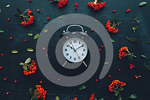 Alarm clock on dark background, flat lay