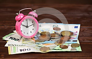 Alarm clock with euro money bills and coins, saving energy, home finances