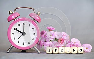 Alarm clock and flowers, spring forward, daylight savings time concept