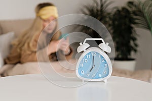 Alarm clock foreground, woman blurred in background