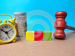 Alarm clock,gavel,banknotes and colored block with copy space