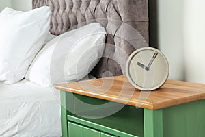 Alarm clock on nightstand in bedroom, space