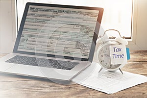 Alarm clock with note tax time. Reminder need to file tax returns, tax form