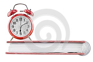 Alarm clock on a notebook isolated on white background