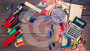 Alarm clock, notebook, pens, calculator and pencils.