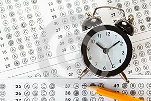 Alarm clock, optical form of standardized school test with bubble and black pencil, answer sheet, education concept