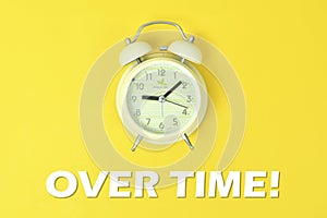 Alarm clock with over time text on yellow background