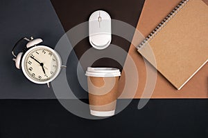 Alarm clock, paper cup, notebook and computer mouse, top view.