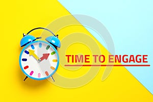 Alarm clock and phrase TIME TO ENGAGE on background, top view