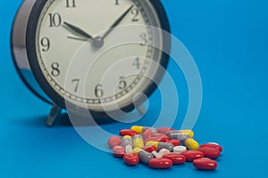 Alarm Clock, Pills, drugs on colorful background. Healthcare concept, Shallow depth of field, soft focus