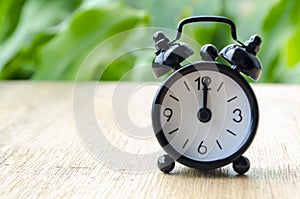 Alarm clock pointing at 12pm with customizable background space for text or ideas.