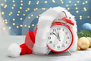 Alarm clock, Santa hat and festive decor on table. Christmas countdown