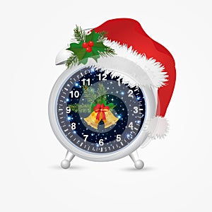 Alarm clock in santa hat with spruce boughs and bells showing new year time. Merry Christmas and new year concept.