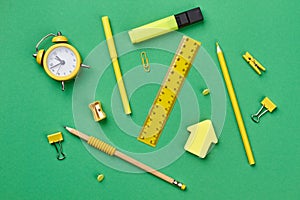 Alarm clock and school supplies on color background.